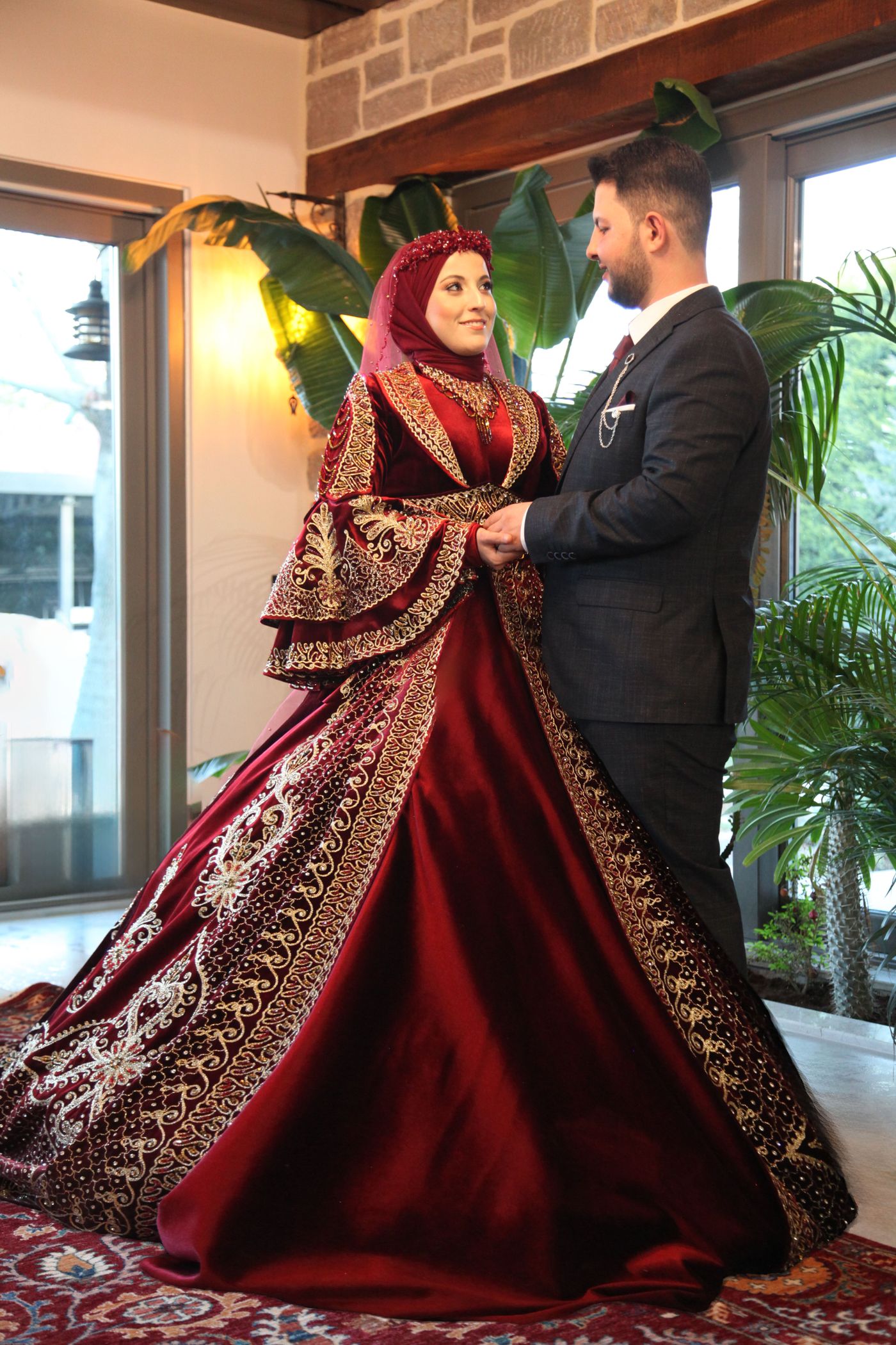 Middle Eastern bride in an embroidered red gown beside her groom