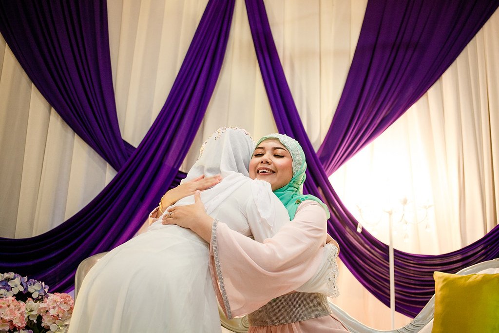 Bride and a family member sharing a joyful hug at a wedding