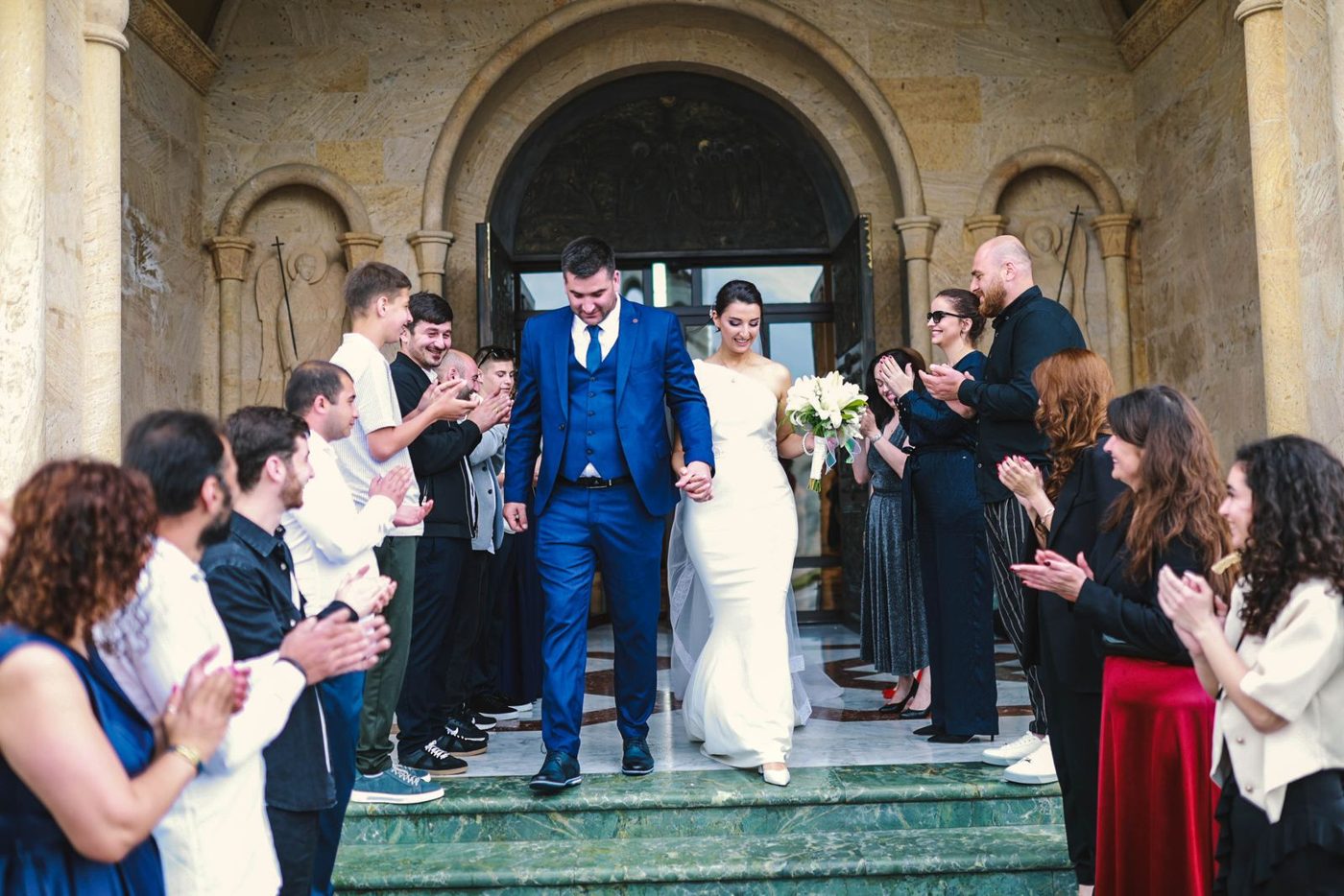 Newlyweds leaving church to applause from guests