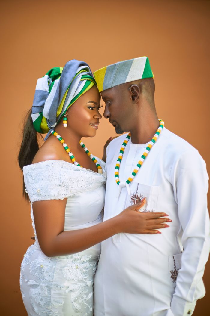 Couple in traditional African wedding attire embracing