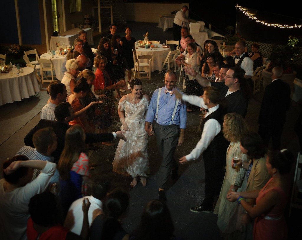 Newlyweds celebrating as guests cheer around them