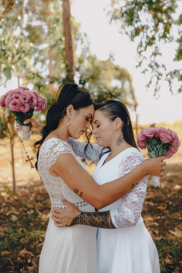 Two brides in wedding dresses embracing