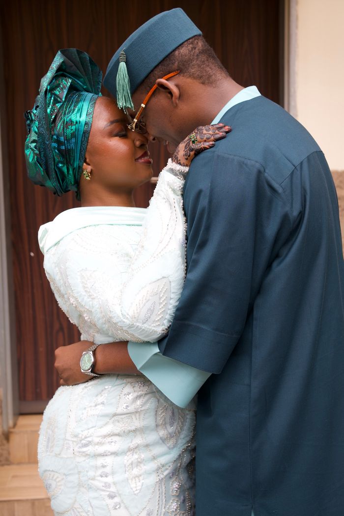 Nigerian bride and groom embracing in traditional attire